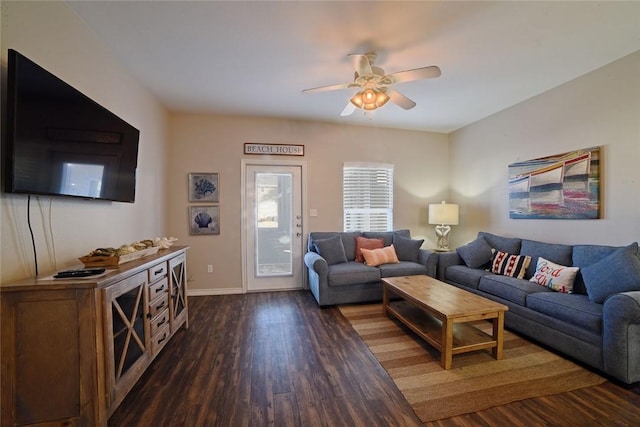 living area with dark wood finished floors, a ceiling fan, and baseboards