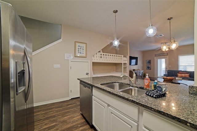kitchen featuring visible vents, a sink, dark wood finished floors, dark stone counters, and appliances with stainless steel finishes