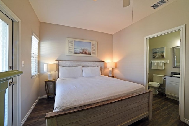 bedroom featuring visible vents, ensuite bathroom, baseboards, and dark wood-style flooring