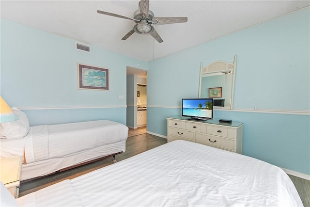 bedroom with visible vents, ceiling fan, baseboards, and wood finished floors