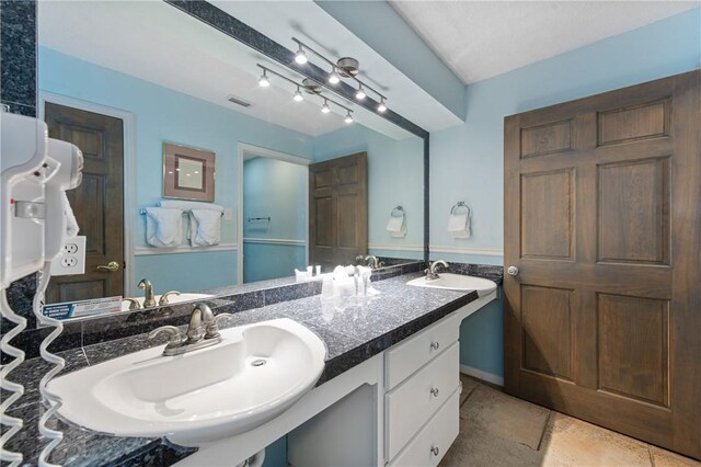 bathroom featuring double vanity, visible vents, and a sink