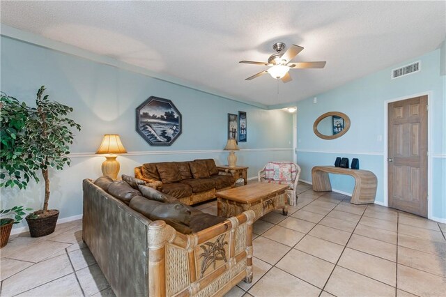 living room featuring ceiling fan, visible vents, baseboards, and light tile patterned flooring