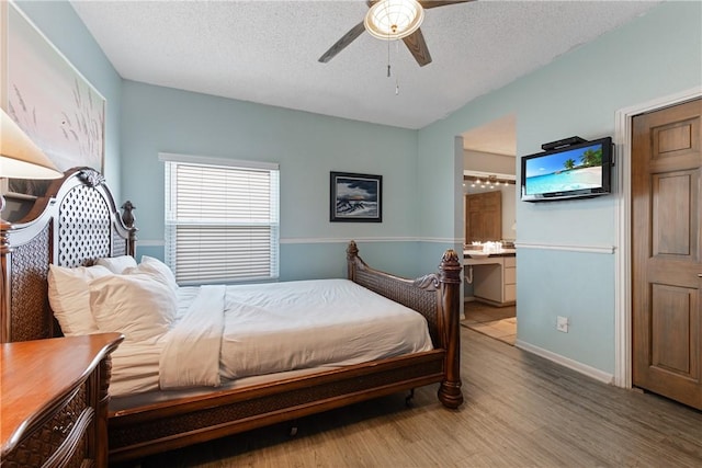 bedroom with connected bathroom, a textured ceiling, wood finished floors, and a ceiling fan