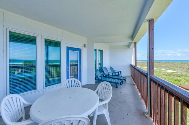 balcony featuring outdoor dining area and a water view