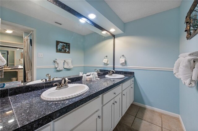 bathroom with double vanity, visible vents, and a sink