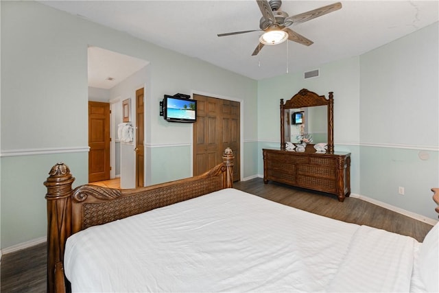 bedroom with visible vents, a ceiling fan, wood finished floors, a closet, and baseboards