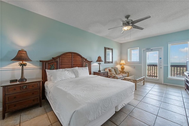 bedroom featuring access to outside, multiple windows, a ceiling fan, and a textured ceiling