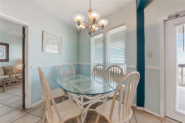 dining room with light tile patterned floors, plenty of natural light, and a chandelier