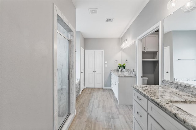 4229 Midlands St, Corpus Christi, TX 78414 - bathroom featuring a shower stall, two vanities, a bath, and wood finished floors