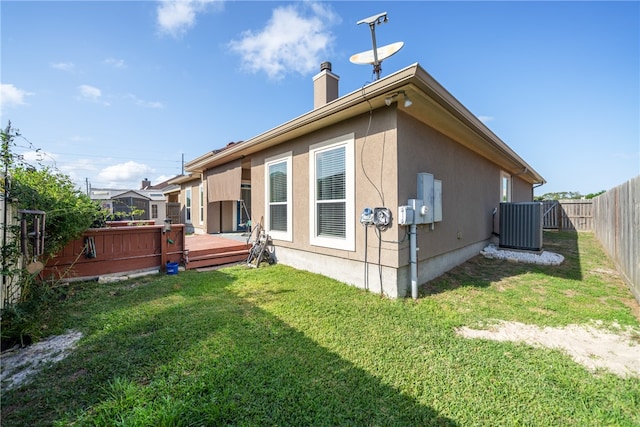 rear view of house featuring central AC, a yard, and a deck