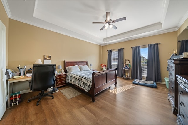 bedroom featuring hardwood / wood-style floors, ceiling fan, and a tray ceiling