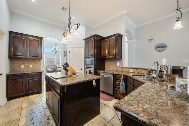 kitchen with stainless steel appliances, dark brown cabinets, decorative light fixtures, and crown molding