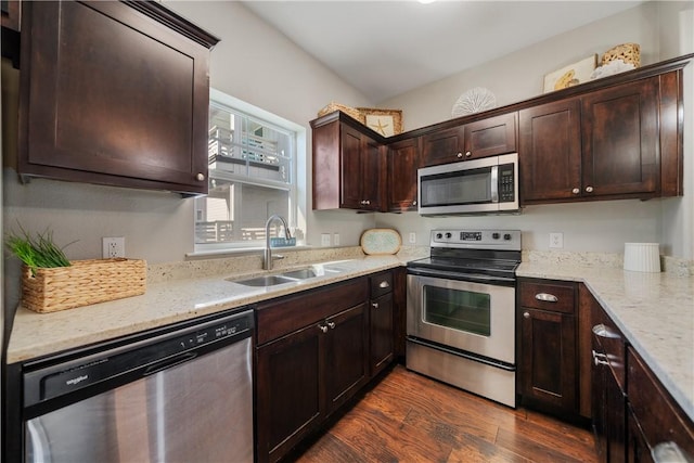 kitchen featuring sink, light stone countertops, dark hardwood / wood-style flooring, dark brown cabinetry, and stainless steel appliances