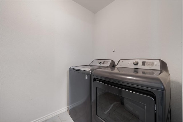 laundry area featuring washer and clothes dryer and light tile patterned floors