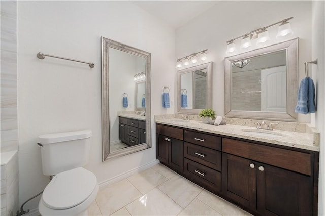 bathroom with toilet, vanity, and tile patterned floors