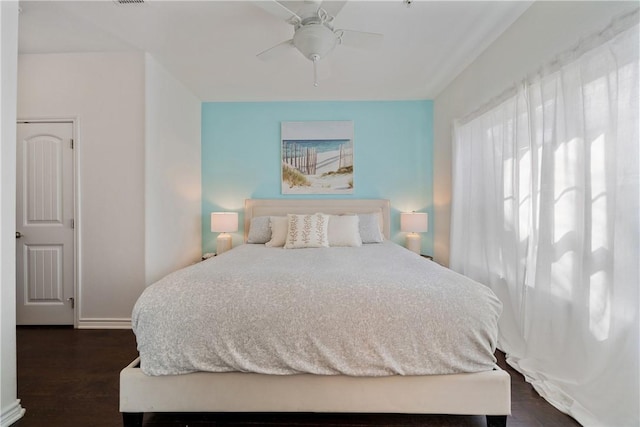 bedroom with dark hardwood / wood-style flooring and ceiling fan