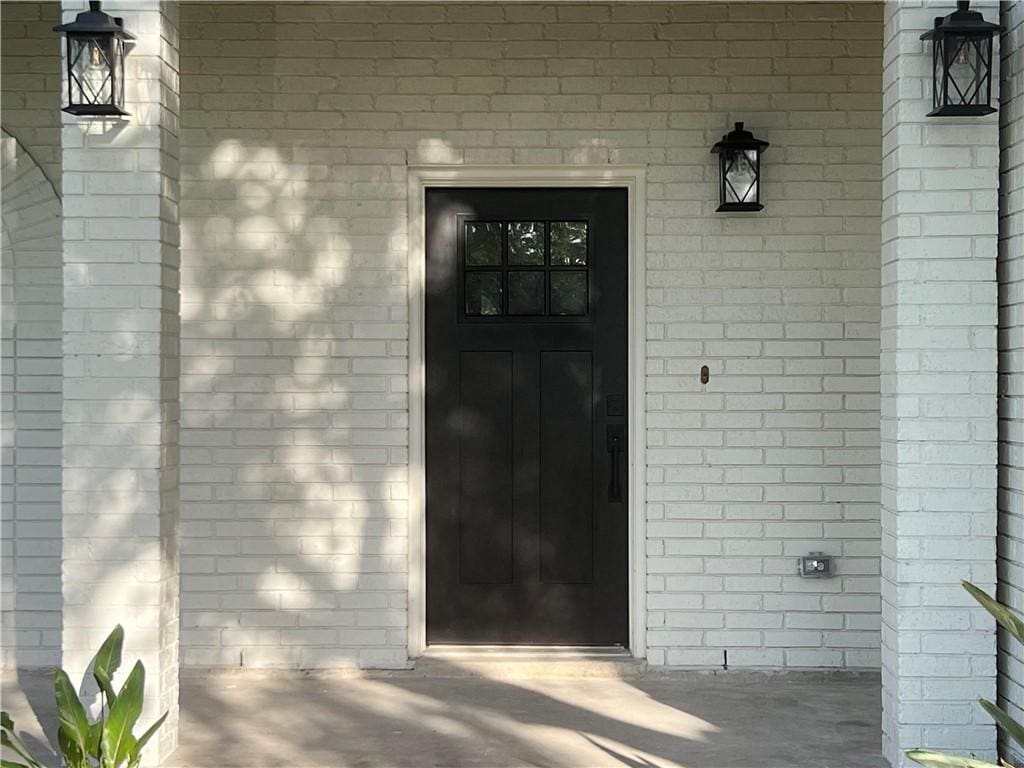 property entrance featuring brick siding