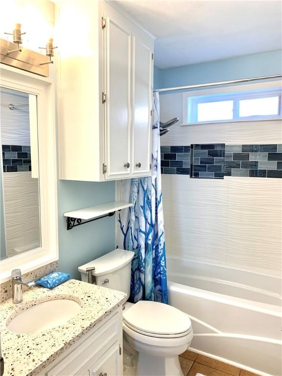 bathroom with toilet, shower / tub combo, tile patterned flooring, and vanity