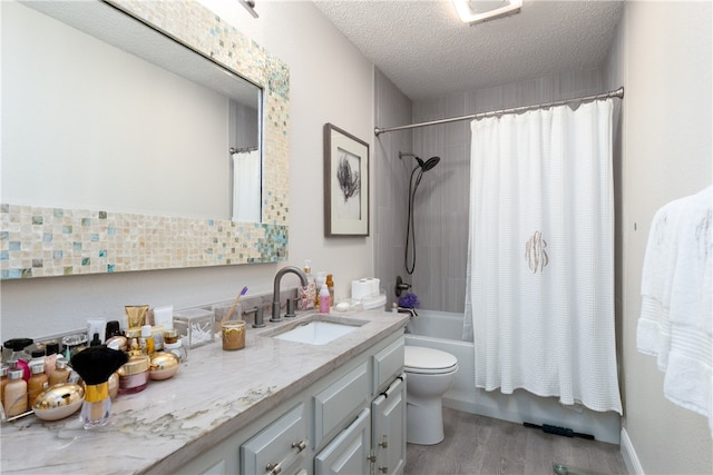 full bathroom with wood-type flooring, vanity, toilet, a textured ceiling, and shower / tub combo with curtain