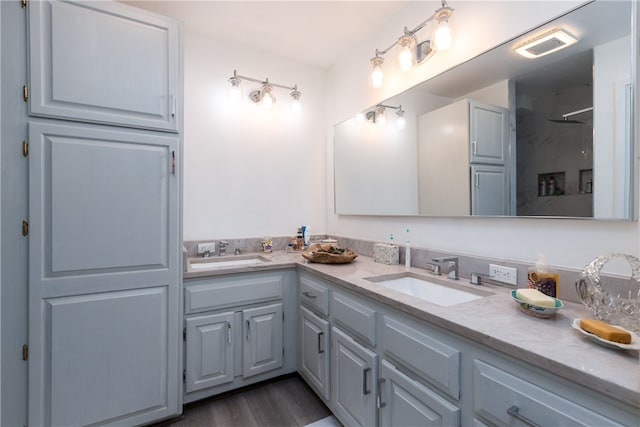 bathroom with hardwood / wood-style floors, vanity, and a shower