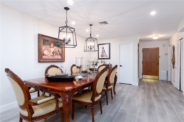 dining room with wood-type flooring and a chandelier