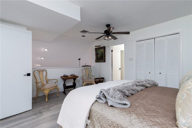 bedroom featuring light hardwood / wood-style flooring, ceiling fan, and a closet