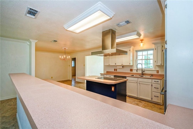 5372 County Road 73a, Robstown, TX 78380 - kitchen featuring island range hood, ornamental molding, a chandelier, light countertops, and a center island