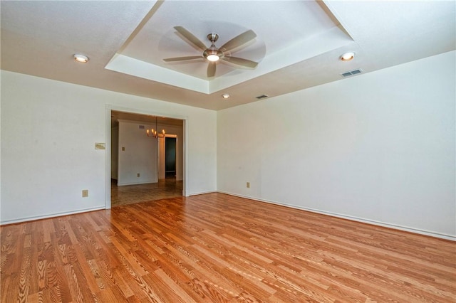 5372 County Road 73a, Robstown, TX 78380 - empty room with a tray ceiling, a ceiling fan, light wood-style flooring, a chandelier, and recessed lighting