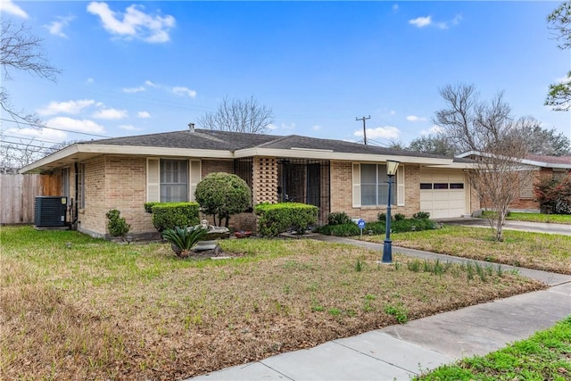 ranch-style house with a garage, a front yard, and central air condition unit