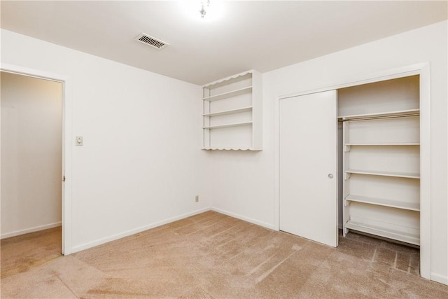 unfurnished bedroom with light carpet and a closet