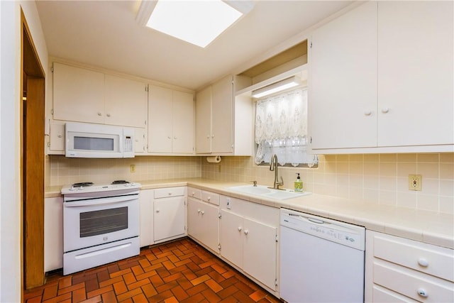 kitchen with backsplash, white appliances, sink, and white cabinets