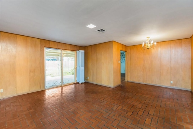 unfurnished room featuring an inviting chandelier