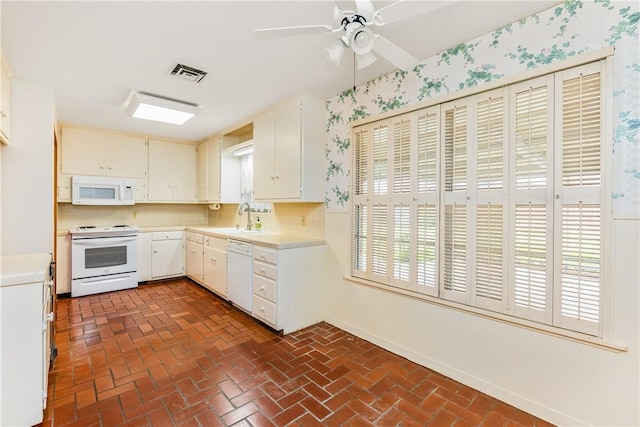 kitchen with sink, ceiling fan, white cabinets, white appliances, and backsplash