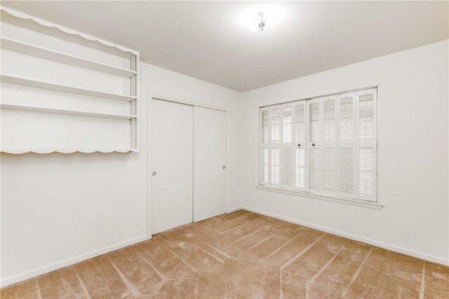 unfurnished bedroom featuring carpet flooring and a closet