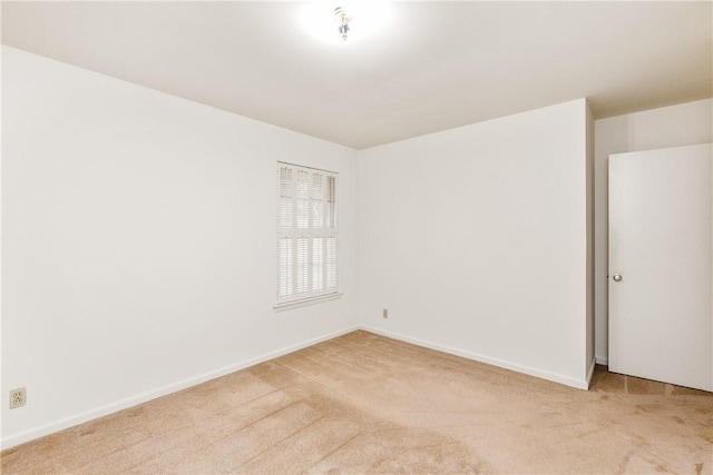 unfurnished room featuring light carpet