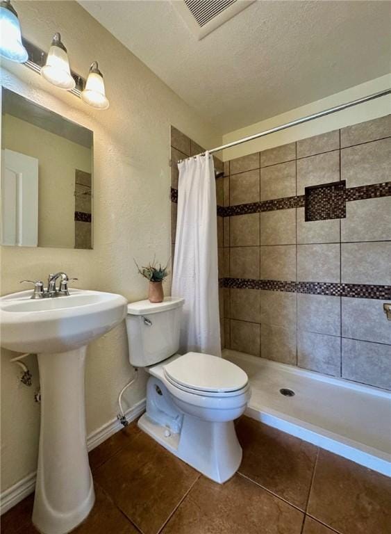 bathroom with sink, tile patterned floors, toilet, and walk in shower