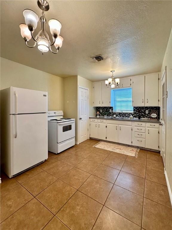 kitchen with decorative light fixtures, white cabinets, a chandelier, light tile patterned floors, and white appliances