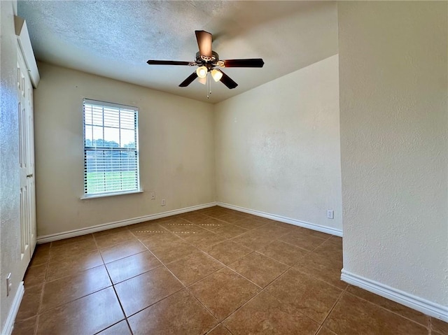 tiled spare room featuring ceiling fan and a textured ceiling