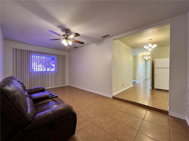 tiled living room with ceiling fan with notable chandelier