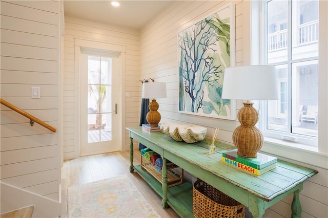 mudroom with wooden walls and light hardwood / wood-style floors