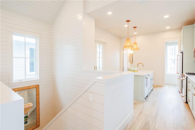 kitchen with light countertops, pendant lighting, light wood-style floors, and a healthy amount of sunlight