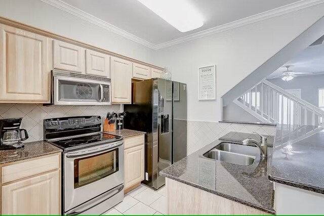 kitchen featuring stainless steel appliances, sink, ornamental molding, ceiling fan, and backsplash