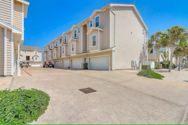 14202 Encantada Ave Unit 303, Corpus Christi, TX 78418 - view of side of property with a residential view, an attached garage, driveway, and cooling unit