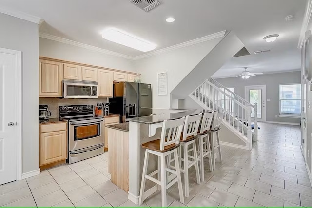 kitchen with tasteful backsplash, ornamental molding, appliances with stainless steel finishes, a kitchen breakfast bar, and ceiling fan