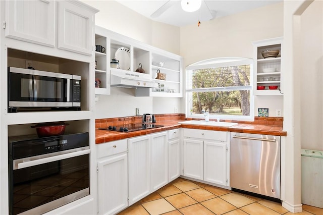 kitchen with under cabinet range hood, appliances with stainless steel finishes, open shelves, and a sink