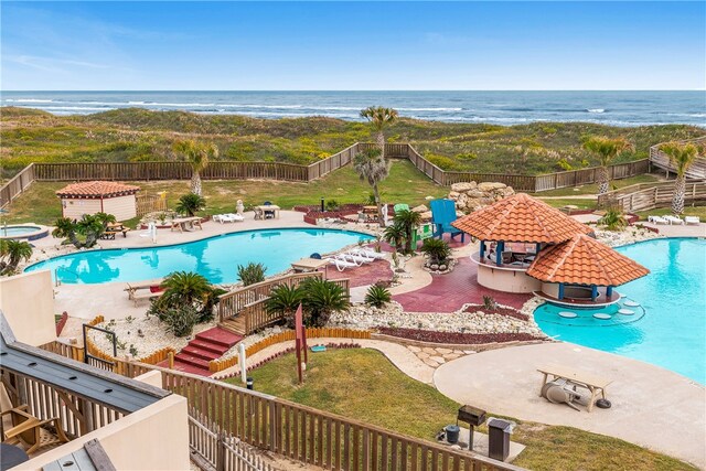 view of pool with a water view, a yard, and a patio area