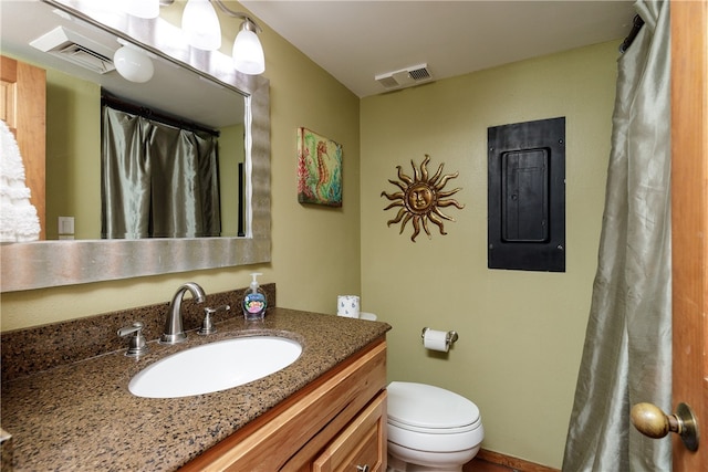 bathroom with electric panel, vanity, and toilet