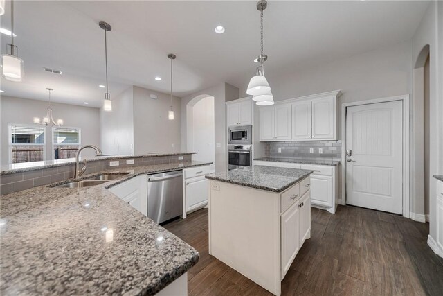 15629 Escapade St, Corpus Christi, TX 78418 - kitchen featuring stainless steel appliances, a sink, arched walkways, tasteful backsplash, and dark wood-style floors