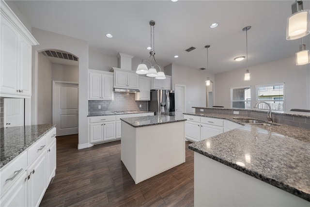 kitchen featuring a center island, stainless steel fridge with ice dispenser, sink, and white cabinets