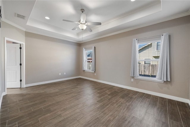 spare room with a raised ceiling and dark wood-type flooring